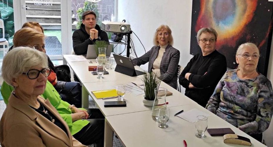 vyresnio amžiaus žmonės mokosi sėdėdami aplink stalą